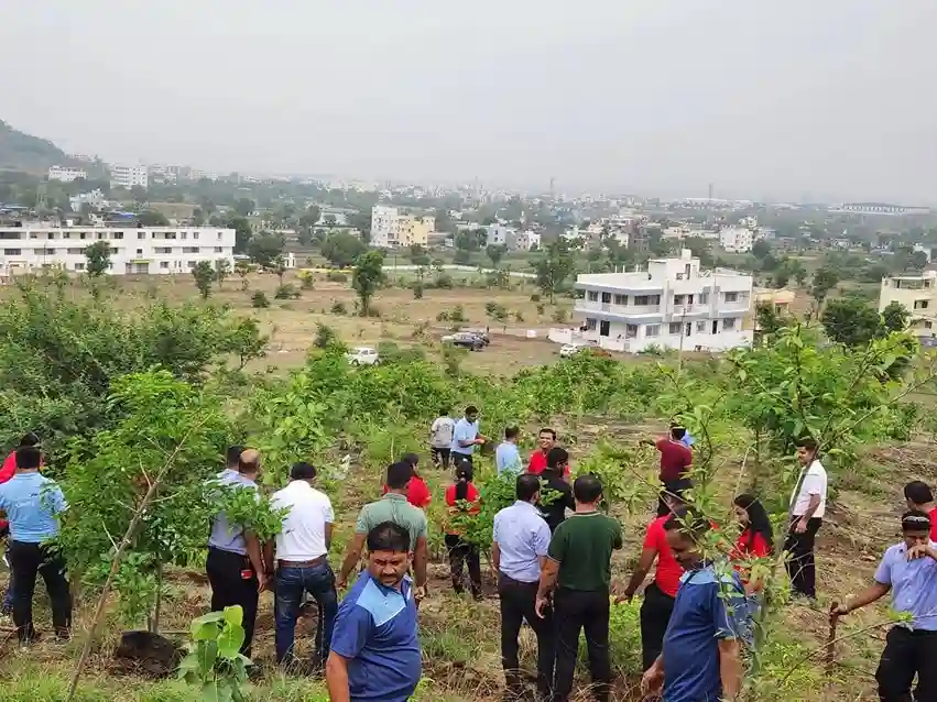 The landscape appears to be semi-urban, with a mix of open land and developed structures. The atmosphere seems to be collaborative, with participants actively involved in the task at hand.